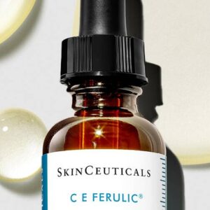 A bottle of SkinCeuticals C E Ferulic serum with scattered droplets.