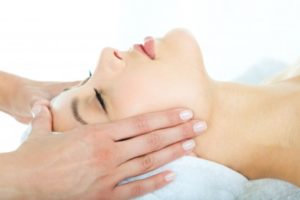 Woman receiving a facial massage.