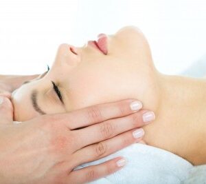 Woman receiving a facial massage.