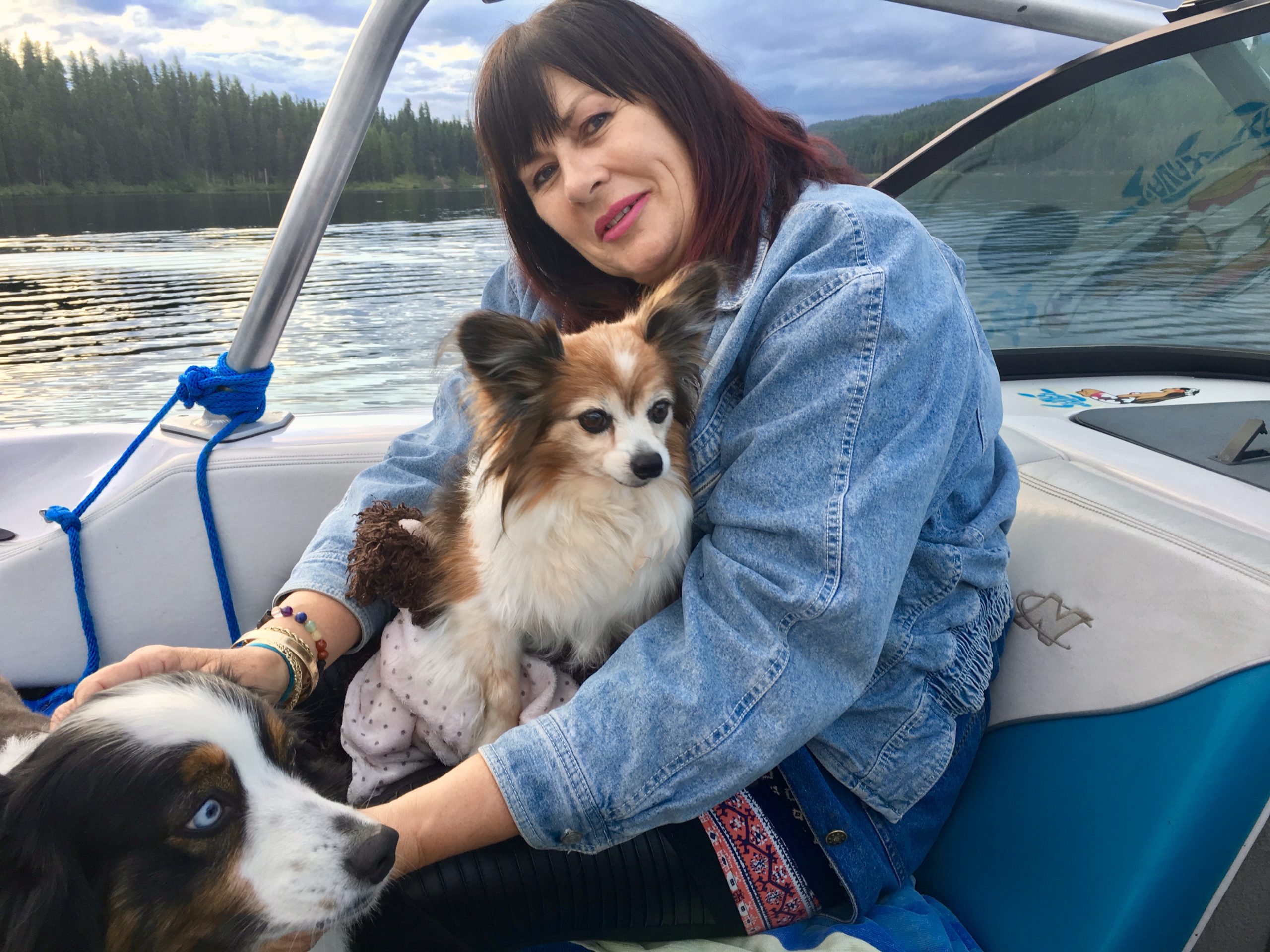 Woman on a boat with two dogs.