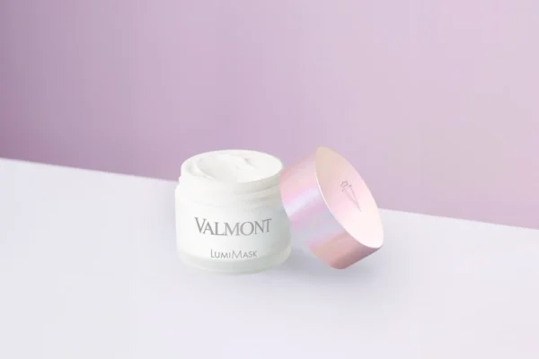 Valmont skincare cream with a pink lid on a purple background.