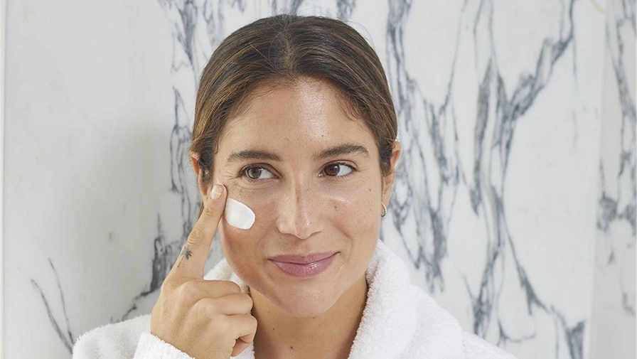 Woman applying cream mask from Valmont to her face